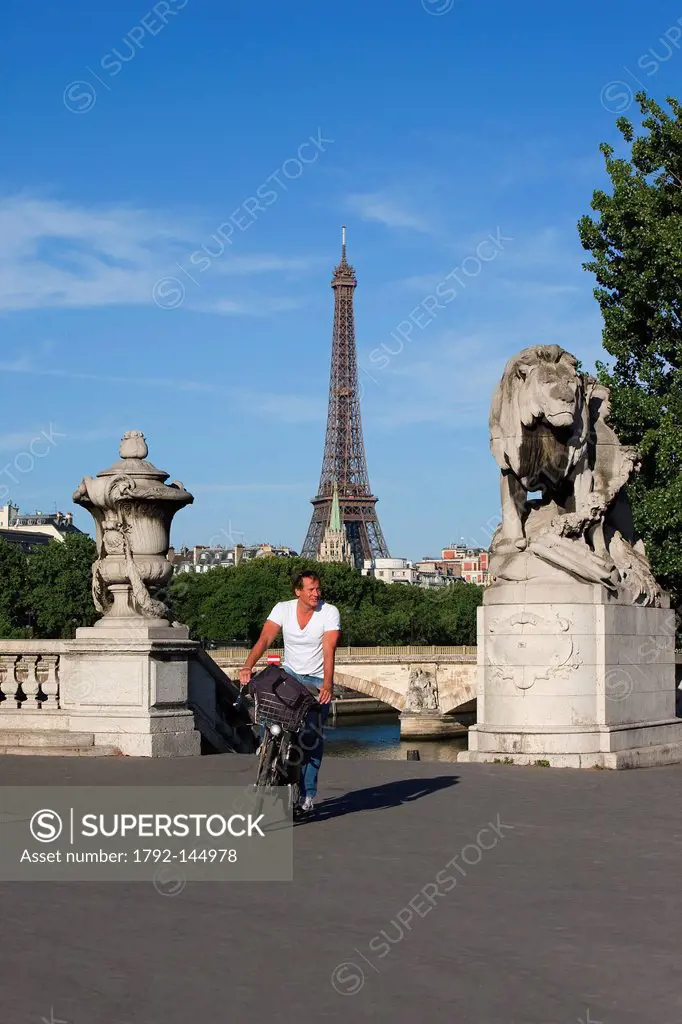 France, Paris, the banks of the Seine river listed as World Heritage by UNESCO, man cycling on Pont Alexandre III Alexander the Third Bridge and Eiffe...
