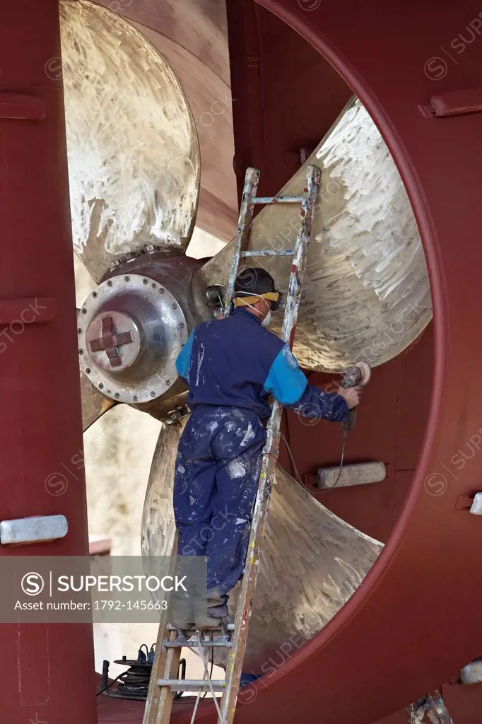 France, Finistere, Concarneau, worker on a boat in the dry dock