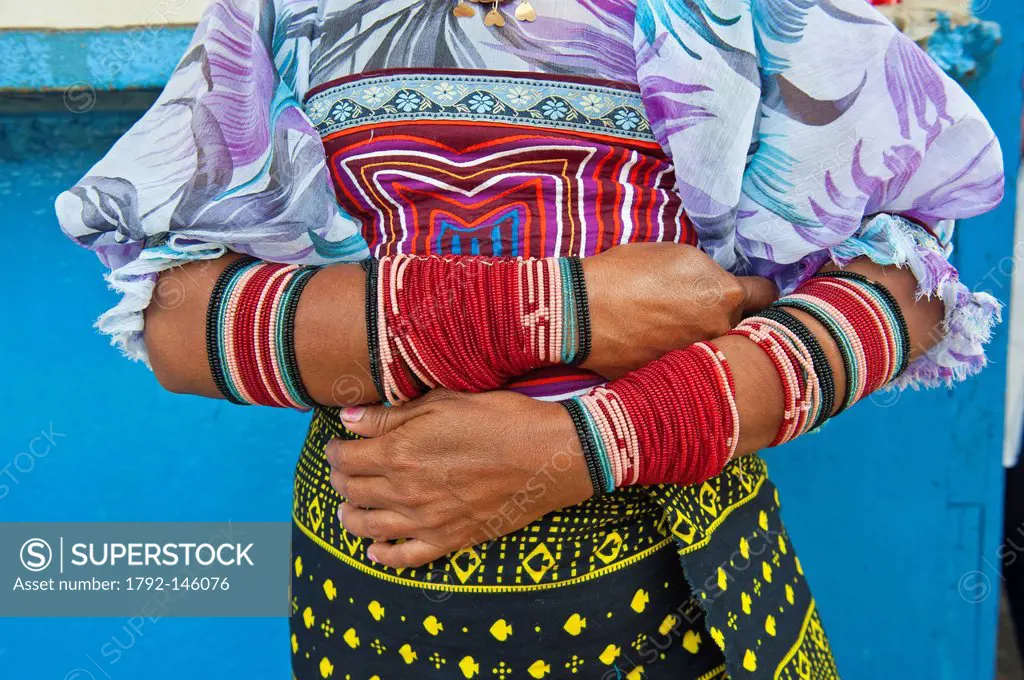 Panama, San Blas archipelago, Kuna Yala autonomous territory, Carti island, Kuna indian showing off her bracelets and molas embroidered textiles