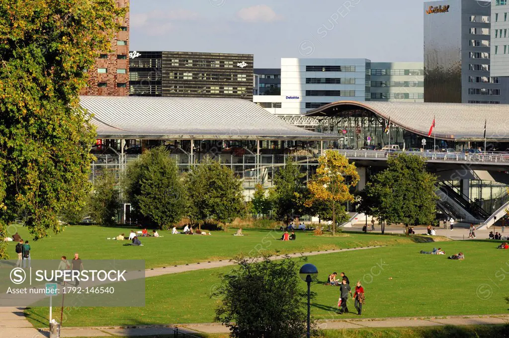 France, Nord, Lille, people in the grass of the Henri Matisse Park and the business district with EuraLille and the Eurostar train station of Lille Eu...