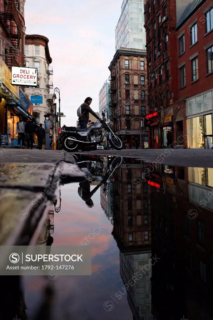 United States, New York City, Manhattan, East Village, reflection of a motorcyclist in a puddle