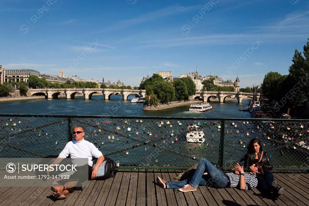 France, Paris, the Seine riverbanks, listed as World Heritage by UNESCO, people on the Pont des Arts and Ile de la Cite in the background