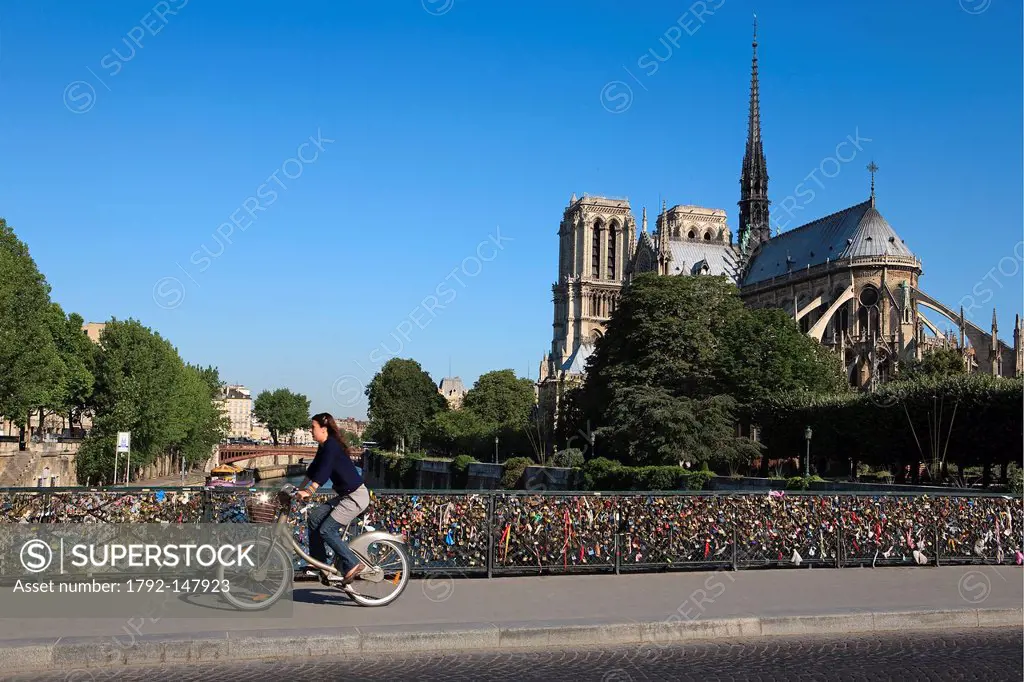 France, Paris, the banks of the Seine River listed as World Heritage by UNESCO, women cycling on the Archeveche bridge and Notre Dame Cathedral