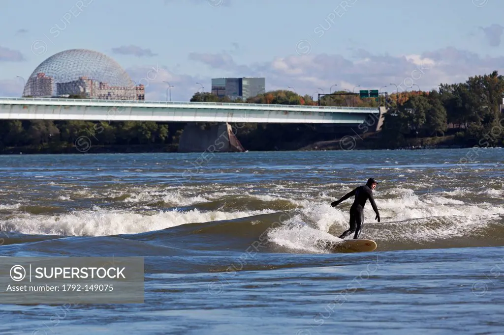Canada, Quebec Province, Montreal, surfer on the St. Lawrence River between the city harbor and Ile Sainte Helene, in the background, Concorde bridge ...