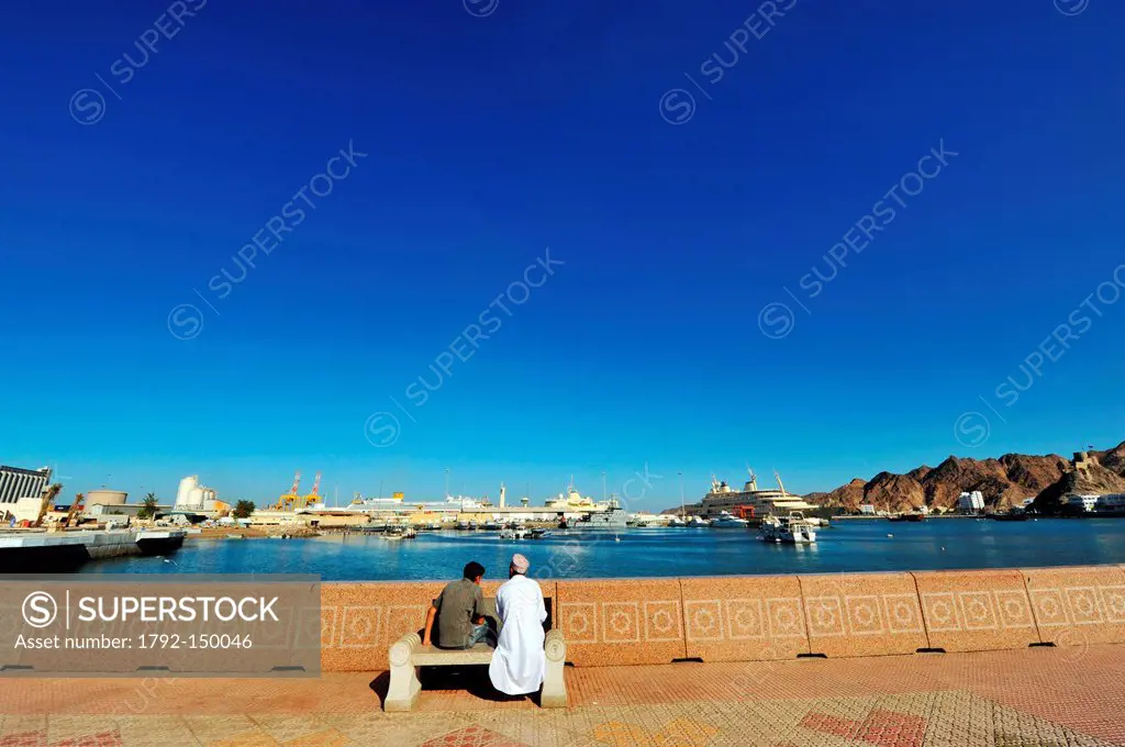 Sultanate of Oman, Muscat, Muttrah port area, Omani men sitting on a public bench on the Corniche