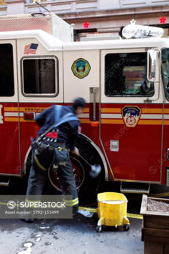 United States, New York City, Manhattan, fireman cleaning a fire truck
