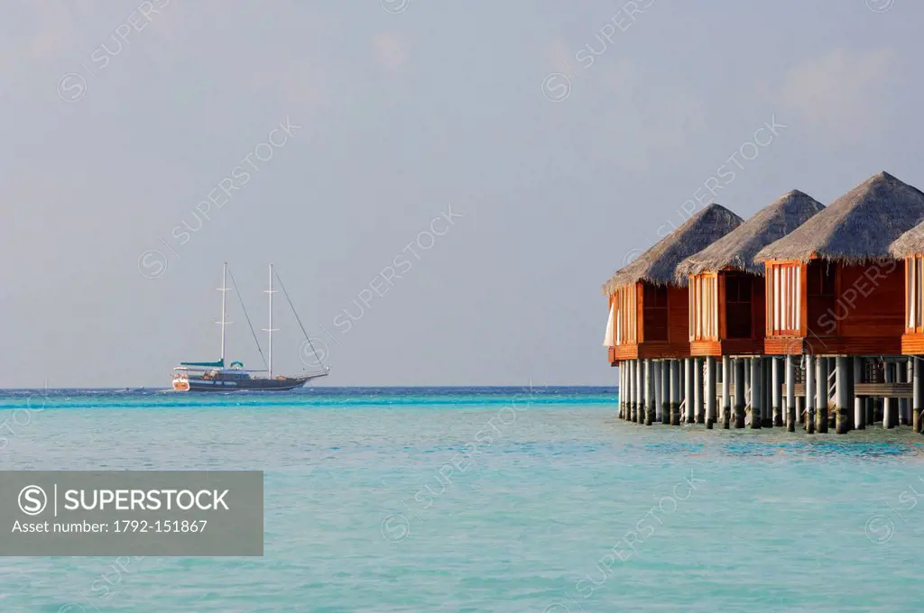 Maldives, South Male Atoll, Dhigu Island, Anantara Resort and Spa Hotel, bungalows on stilts in a lagoon of turquoise with a boat, a schooner on the h...