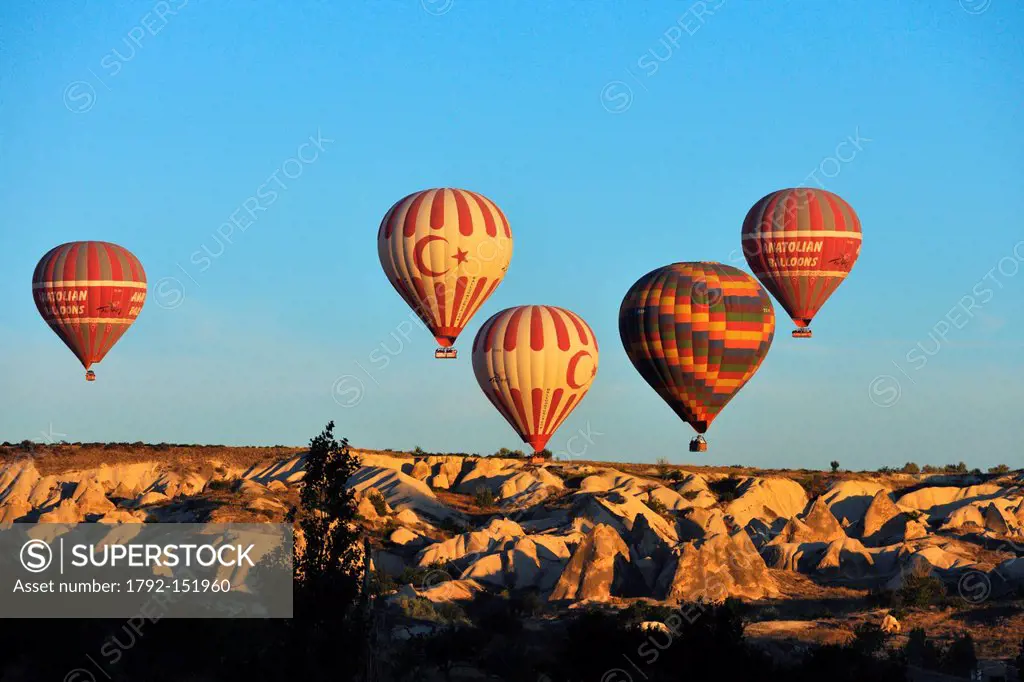 Turkey, Central Anatolia, Nevsehir Province, Cappadocia listed as World Heritage by UNESCO, hot air baloon flying over an eroded landscape and fairy c...