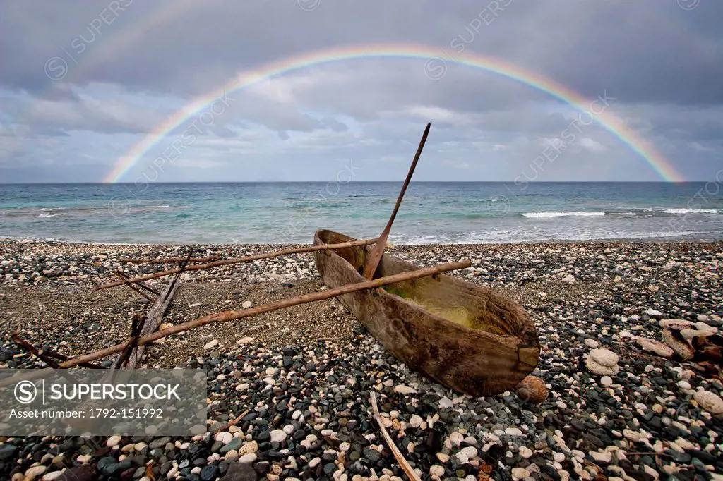 Vanuatu, Penama Province, Pentecost Island, Pangi, dugout canoe on a pebble beach and rainbow over the sea