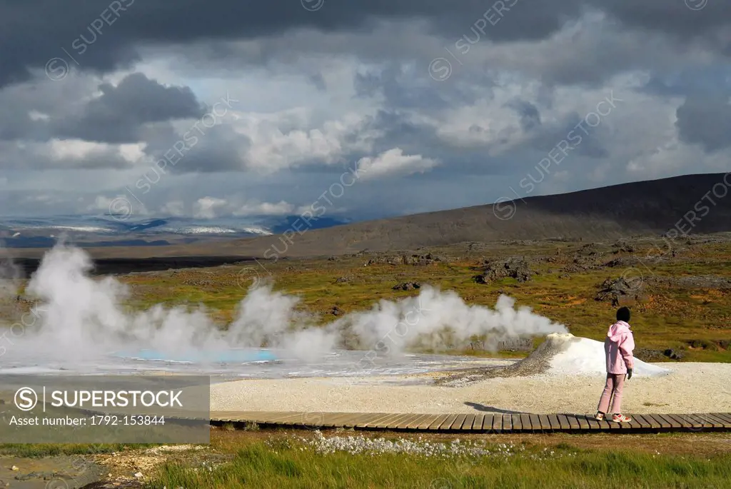 Iceland, Nordurland Vestra Region, Hveravellir, fumarole on a concretion of geyserite and spring of warm water opaline, in the foreground woman from b...