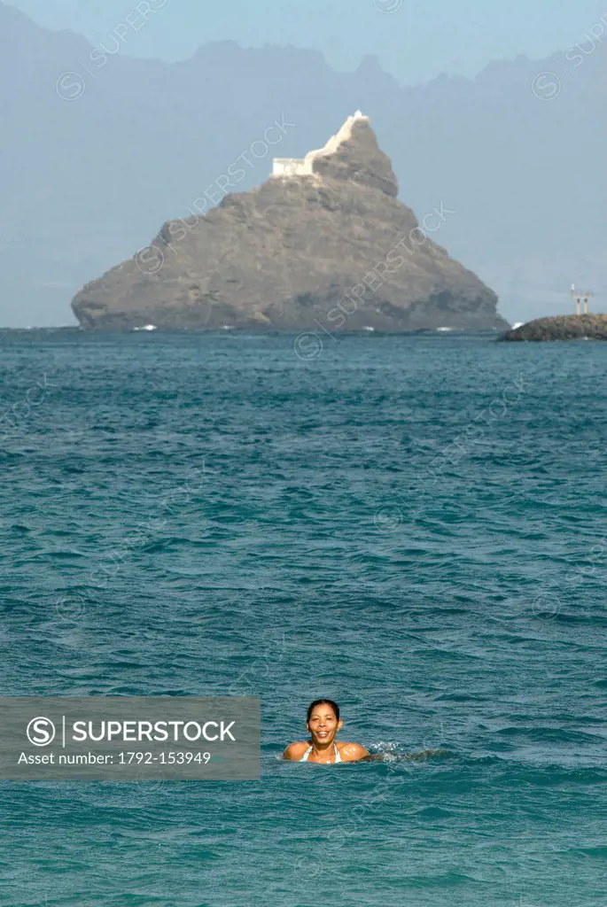 Cape Verde, Sao Vicente island, Mindelo, woman bathing in front of the lighthouse of Ilheu dos passaros which guards the port of Mindelo