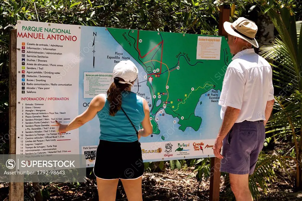 Costa Rica, Puntarenas Province, Manuel Antonio National Park, tourists watching at a map
