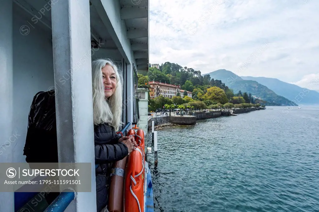 Mature woman smiling on ferry on Lake Como, Italy