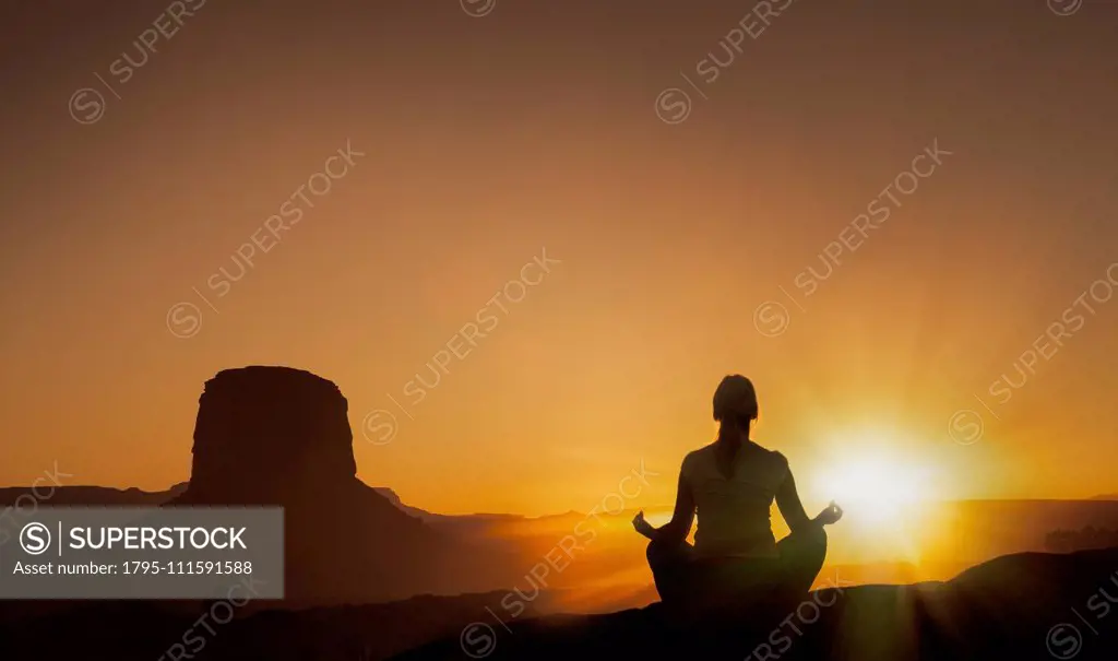 Woman meditating at sunset in Monument Valley Navajo Tribal Park, USA