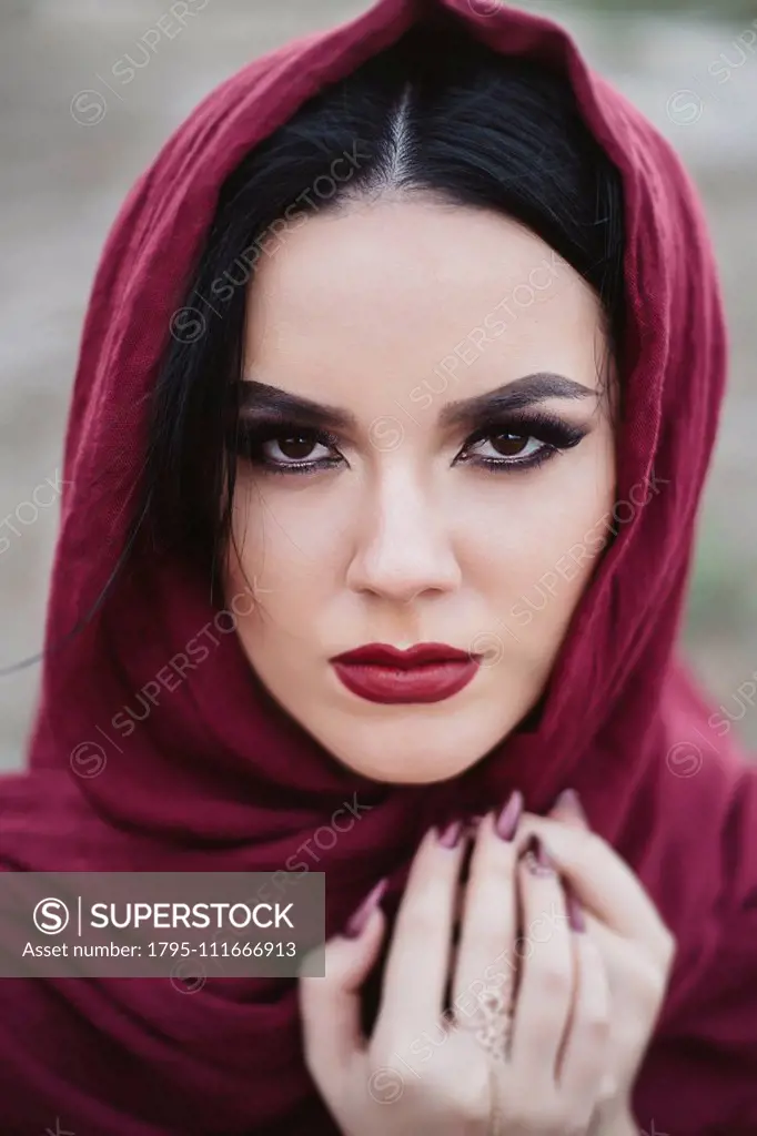 Portrait of young woman wearing red lipstick and headscarf