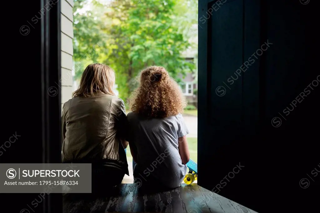 Mother and daughter sitting on porch