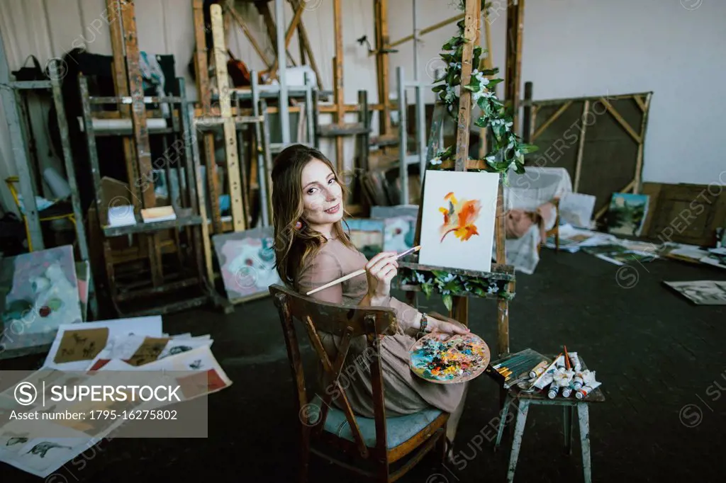 Woman painting on canvas in art studio