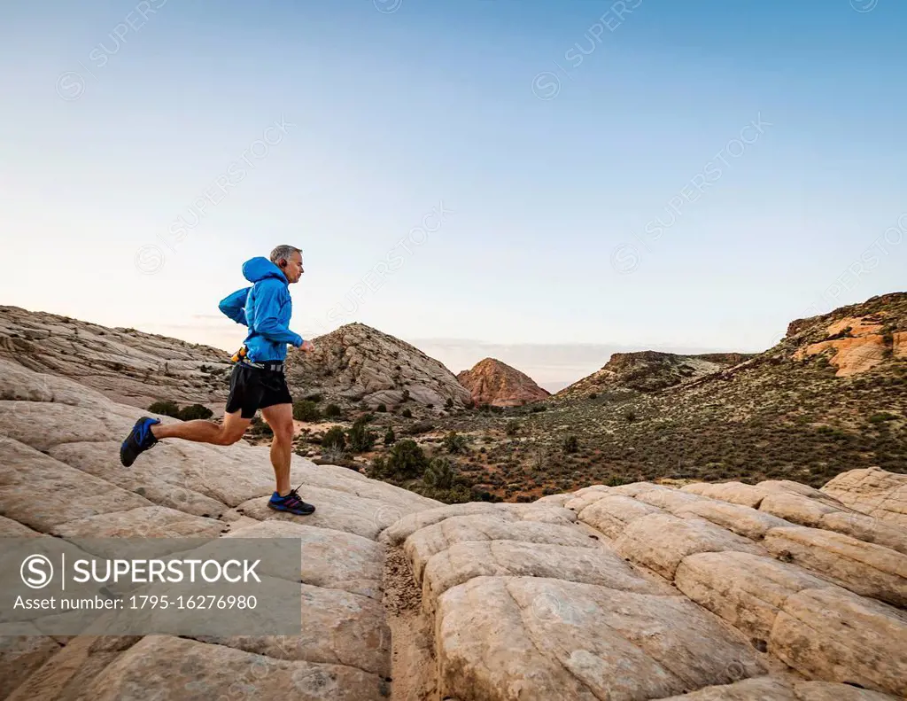 USA, Utah, St. George, Man running in rocky landscape