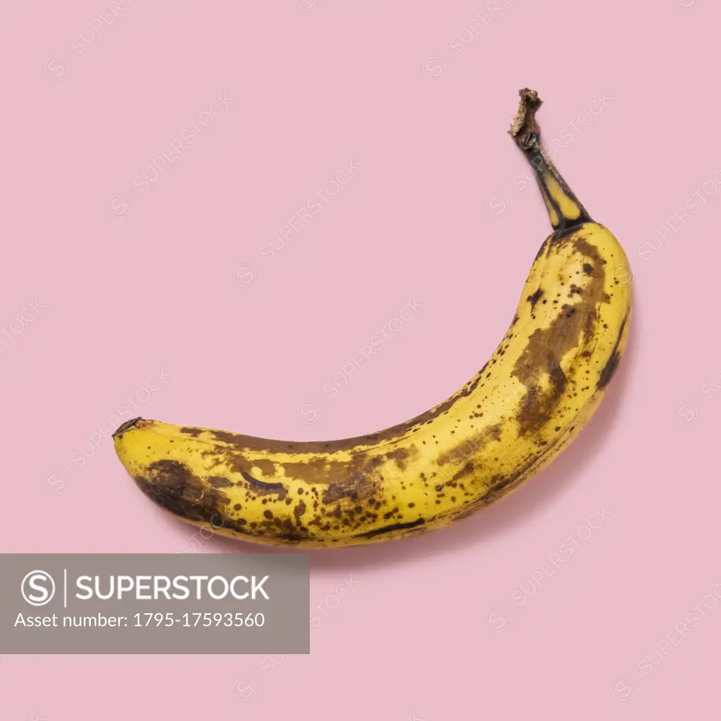 Overripe banana on pink background
