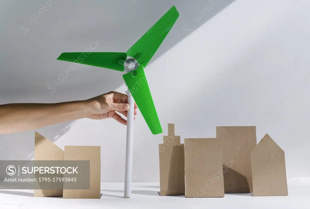 Woman's hand holding scale model of wind turbine