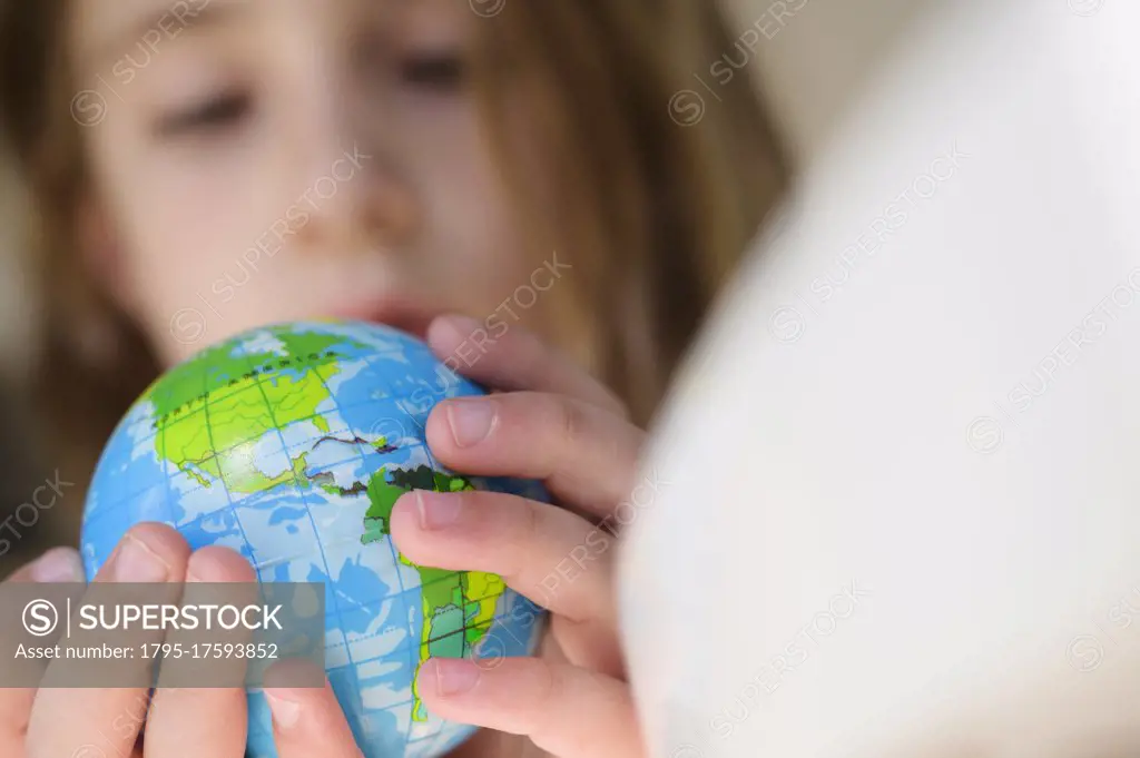 Girl (6-7) holding globe