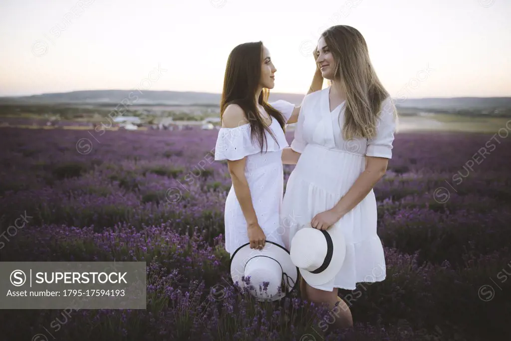 France, Young couple in white dresses standing in lavender field