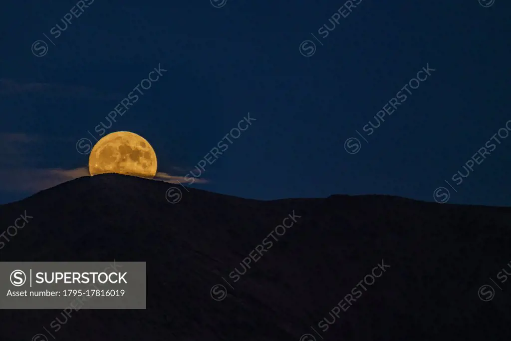 USA, Idaho, Bellevue, Full moon rising over mountains at night
