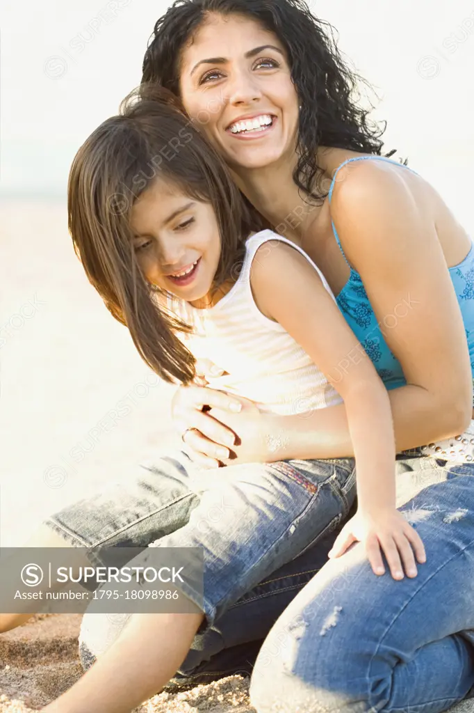 Mixed race mother holding daughter in lap