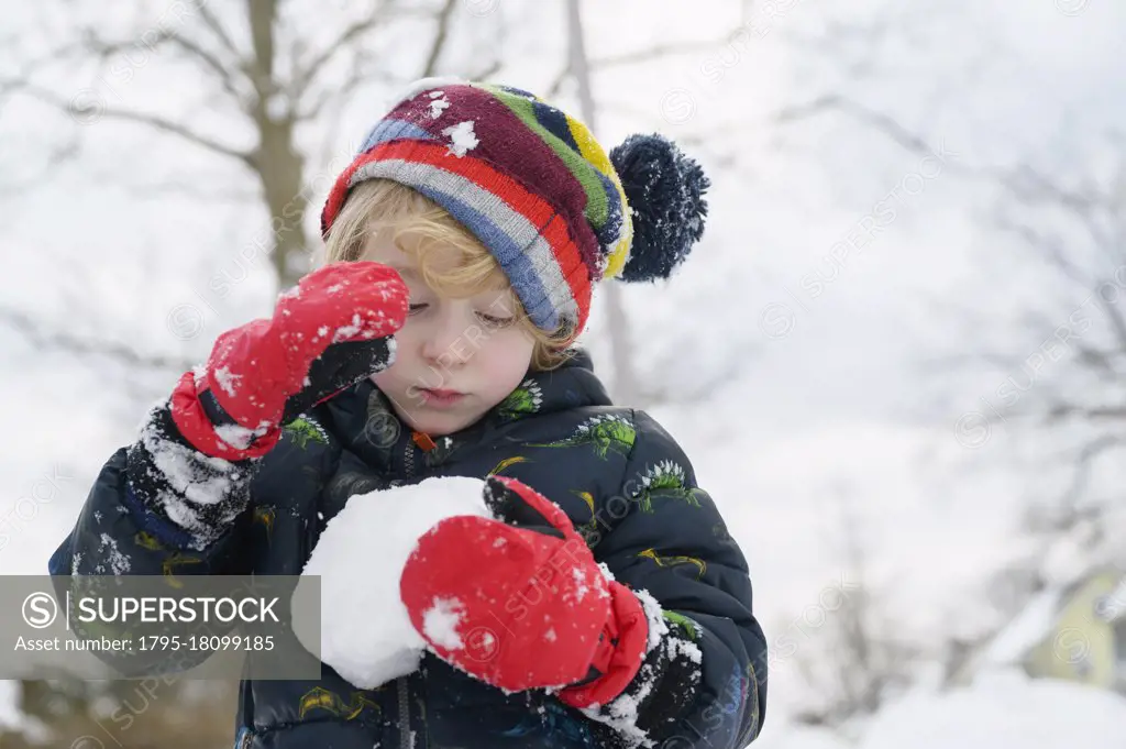 Boy (6-7) holding snowball
