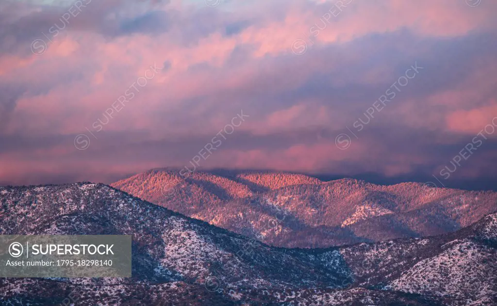 USA, New Mexico, Santa Fe, Colorful clouds at sunset over Sangre de Cristo Mountains
