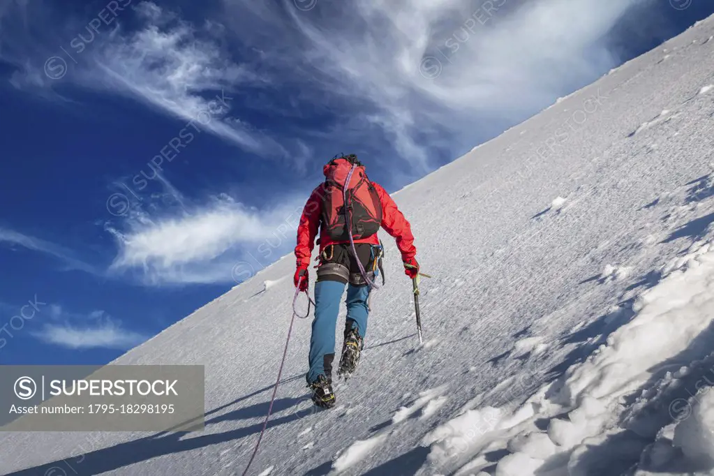 Switzerland, Canton Bern, Jungfrau, Climber ascending snowy mountain