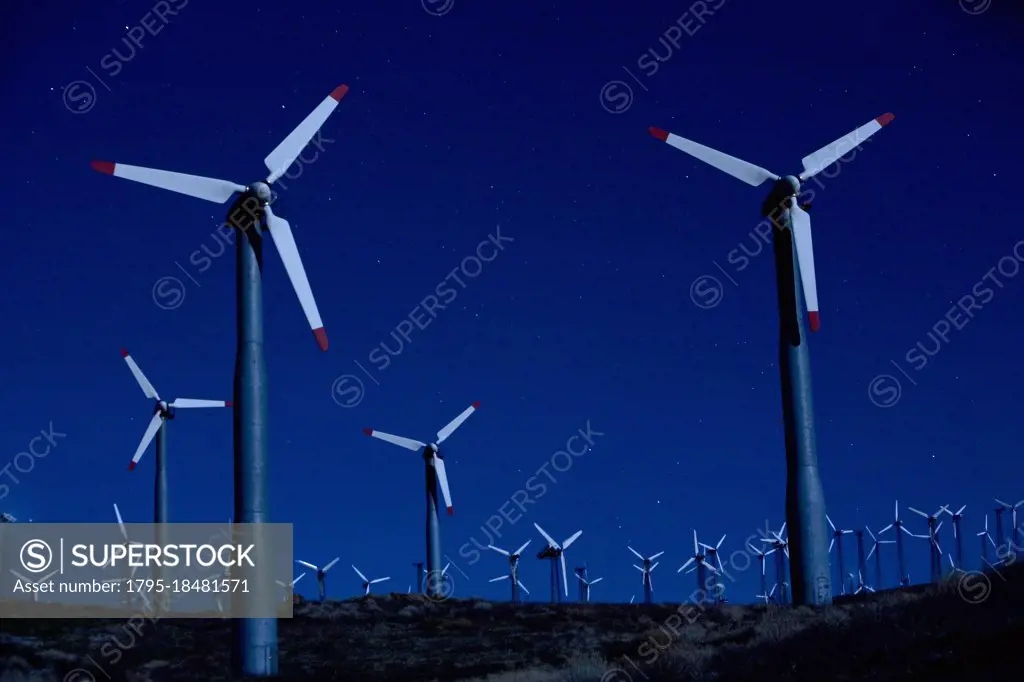 Wind turbines in landscape at night