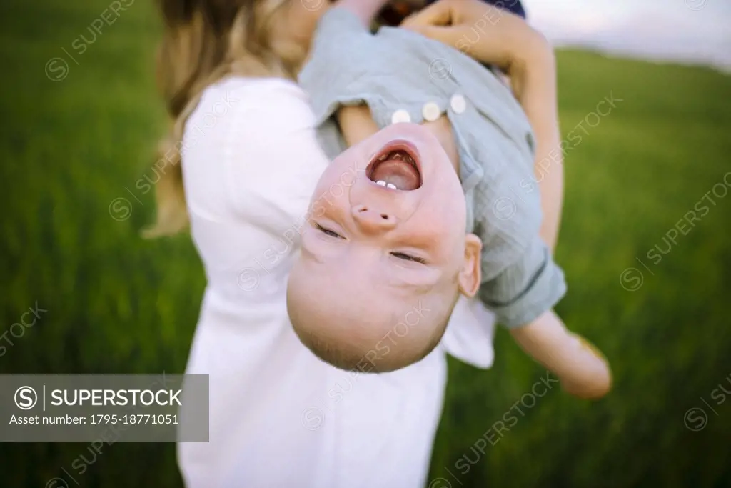 Mother playing with baby son (12-17 months) in agricultural field