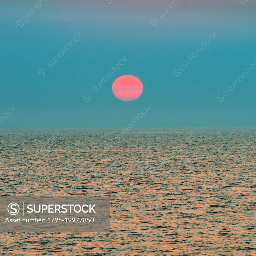 Red setting sun over ocean