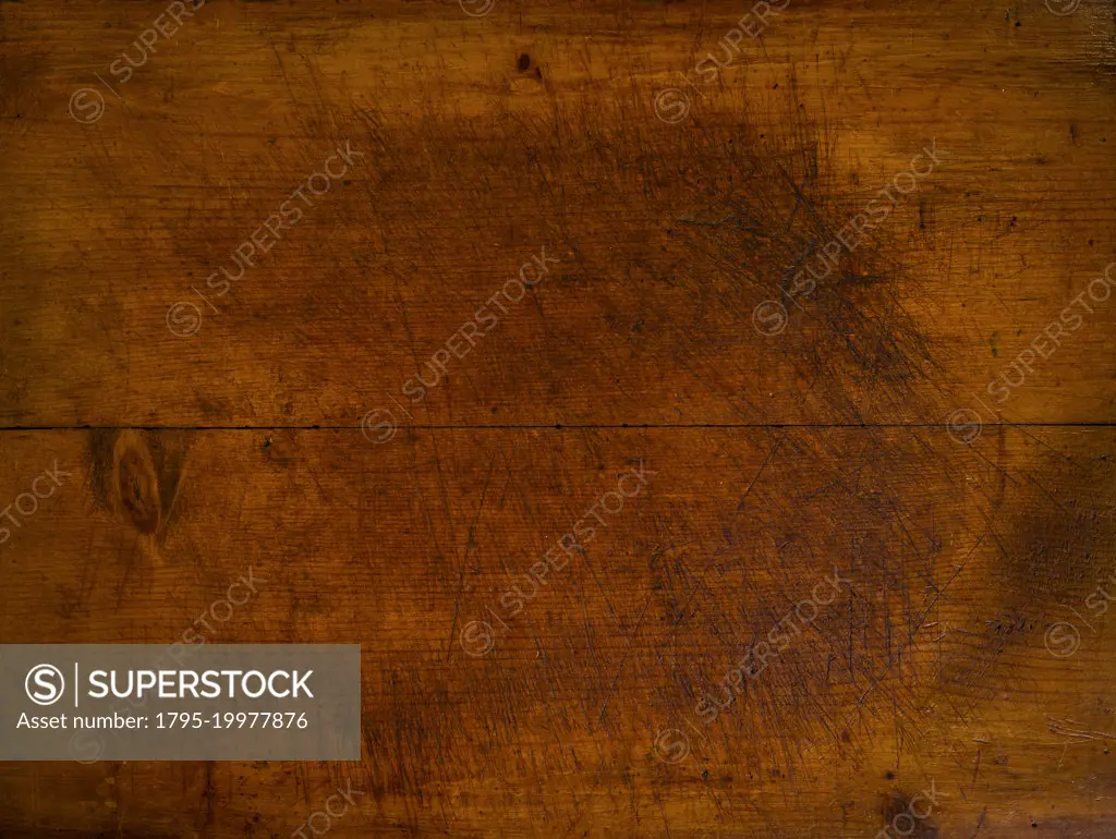 Close-up of worn antique cutting board with knife cut marks