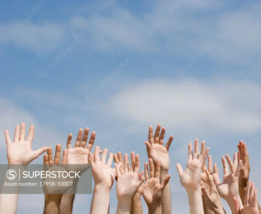 Hands raised under blue sky