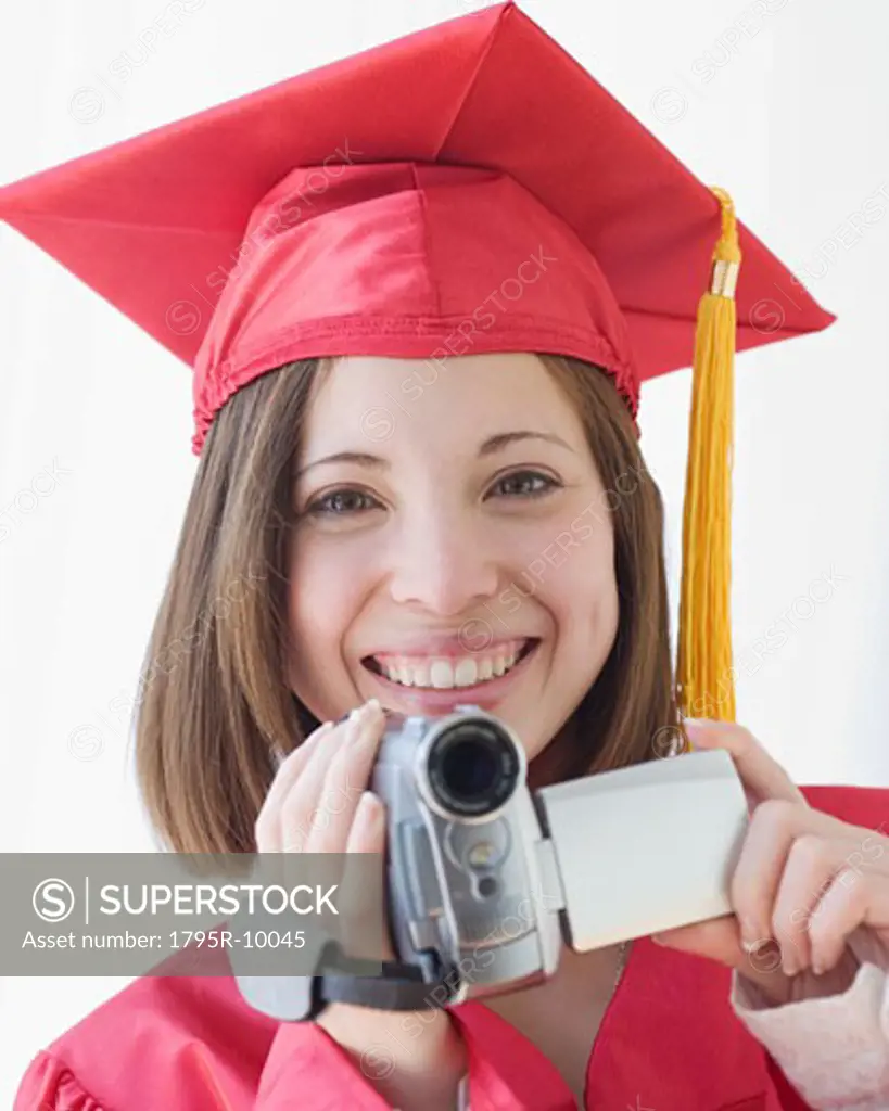 Female graduate holding video camera