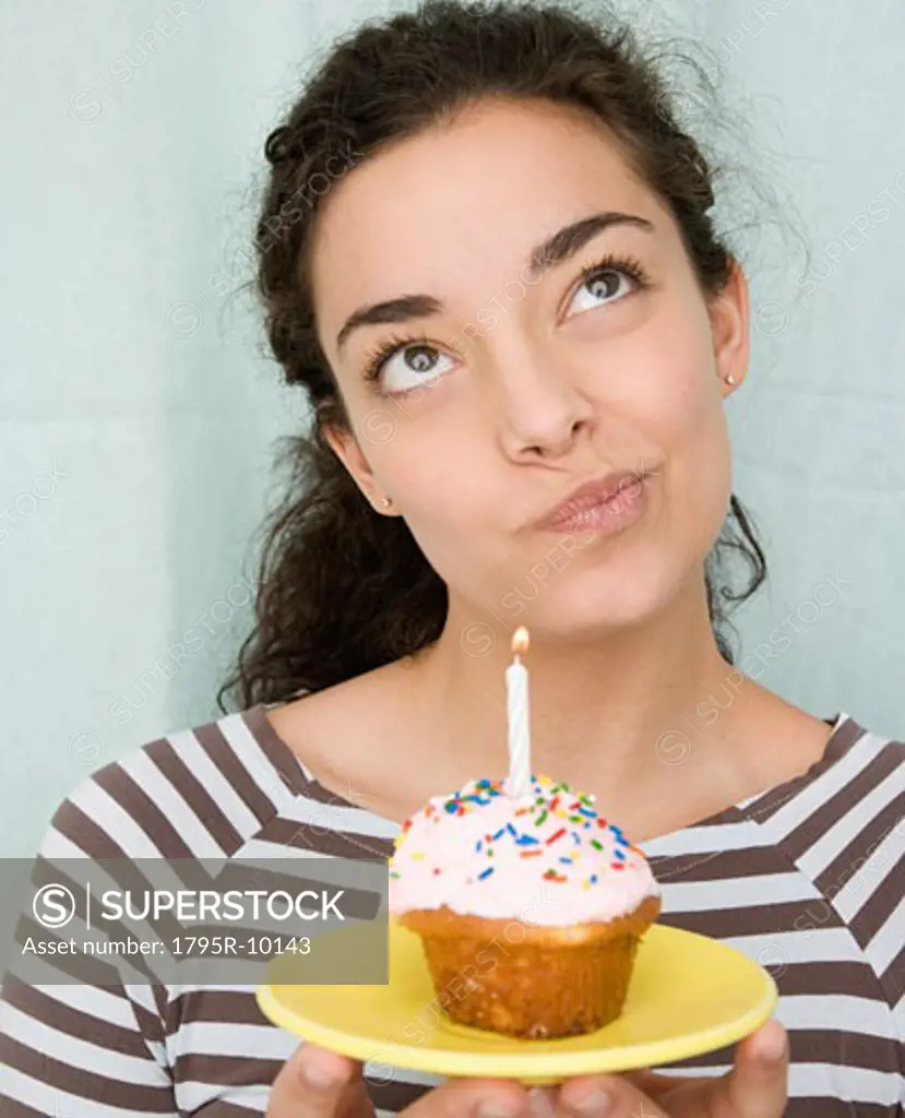 Woman holding cupcake with candle
