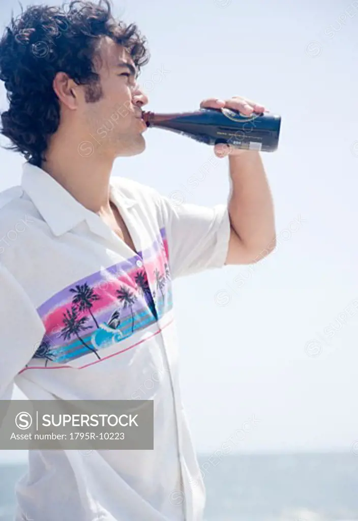Man drinking bottle at beach