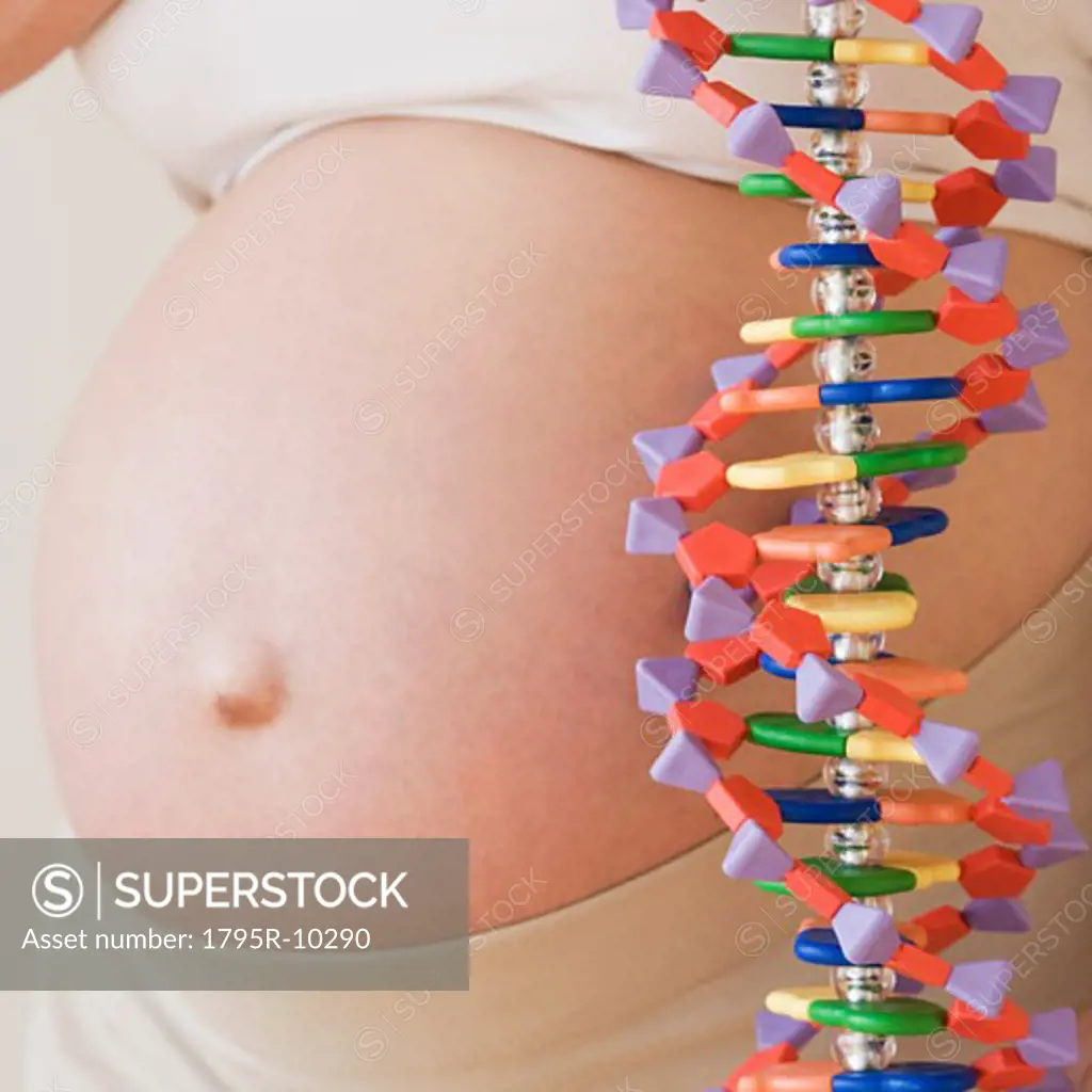 Pregnant woman next to DNA model