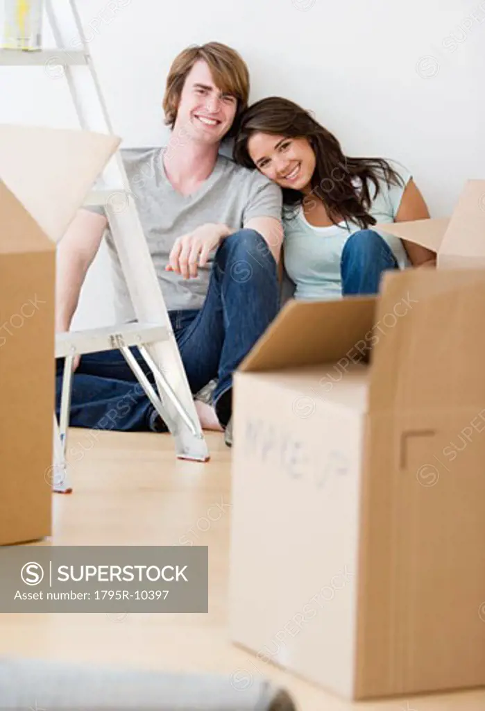 Couple sitting next to moving boxes