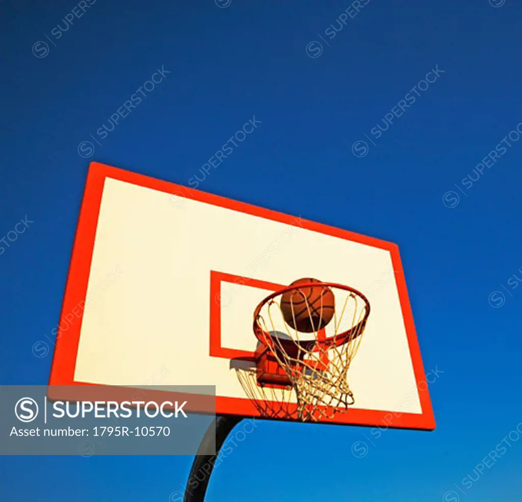 Basketball in mid air over hoop