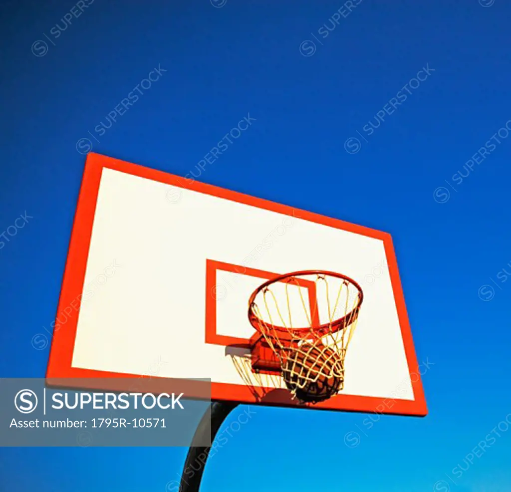 Basketball in mid air over hoop