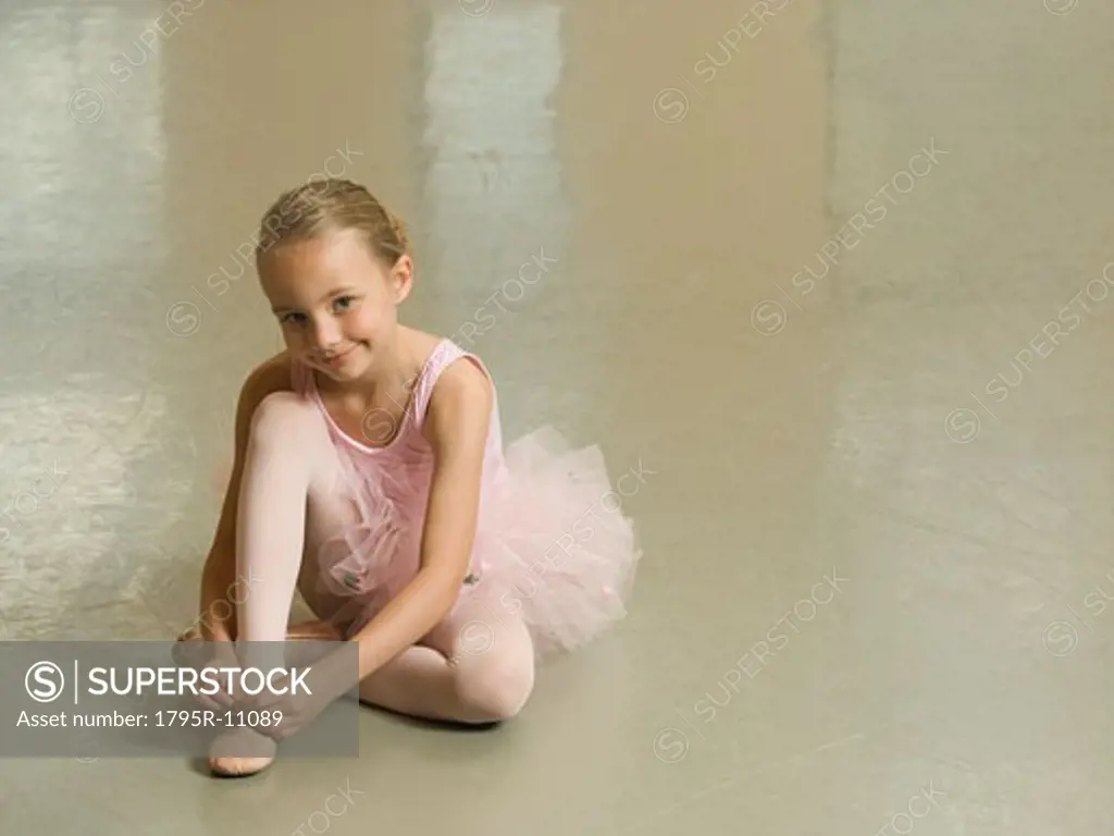 Girl tying ballet shoe