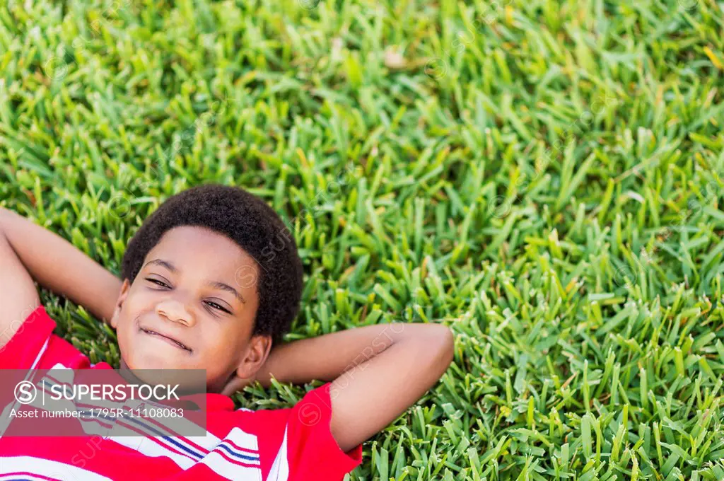 boy (6-7) lying on grass
