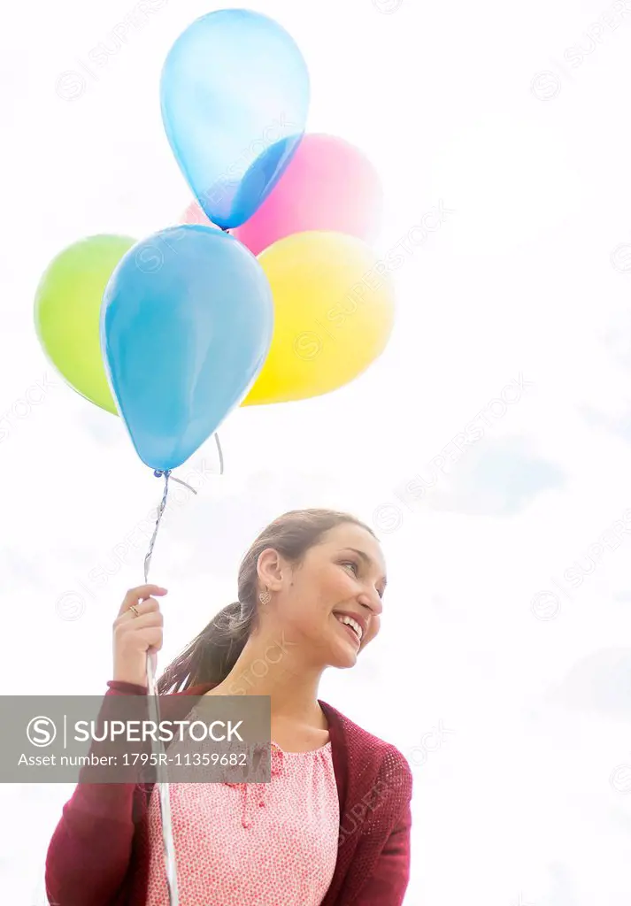 Young woman with colorful balloons