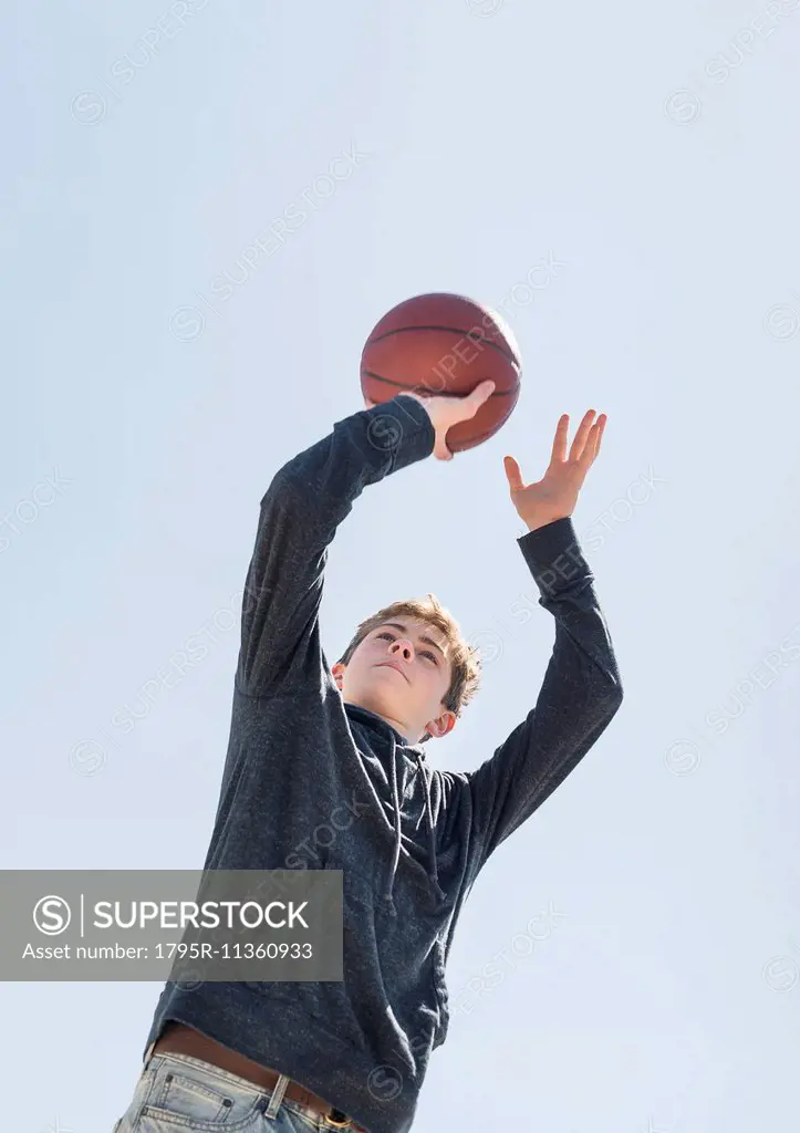 Teenage boy (16-17) playing basketball