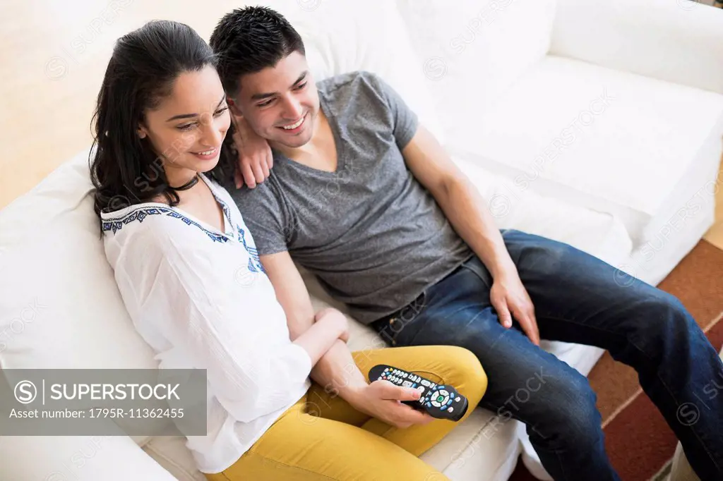 Young couple watching tv on sofa
