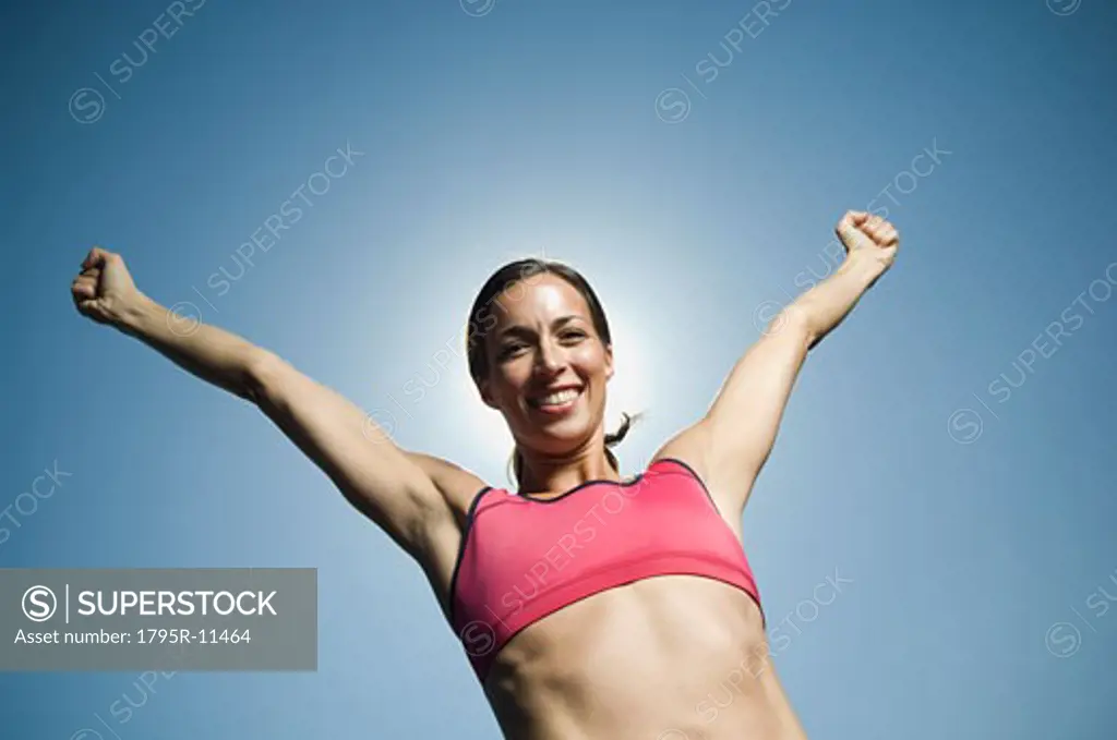 Woman in athletic gear with arms raised