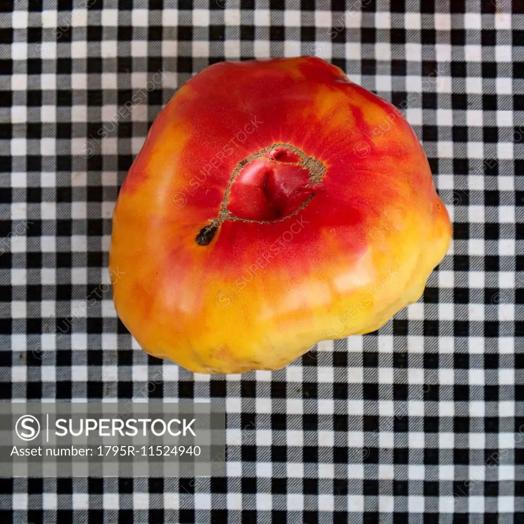 Heirloom tomato on checkered tablecloth